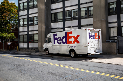 A Fed Ex delivery truck at a downtown Boston location making a delivery of packages.