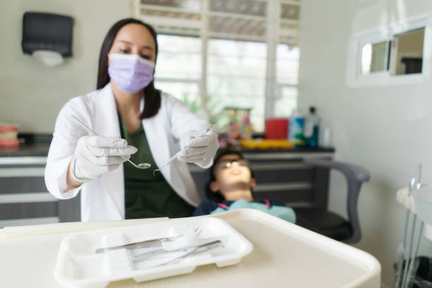 istock Female dentist putting dental instruments away 1418292065