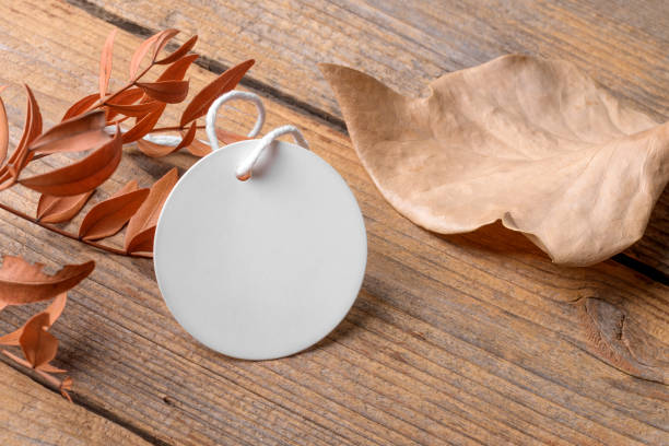istock Round white tag mockup on a rustic wooden background with cotton string and boho decoration 1418292337