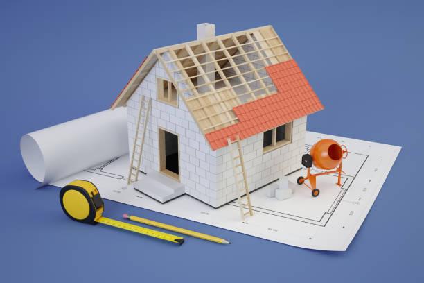 istock House construction, plans and cement mixer, blue background 1418295758