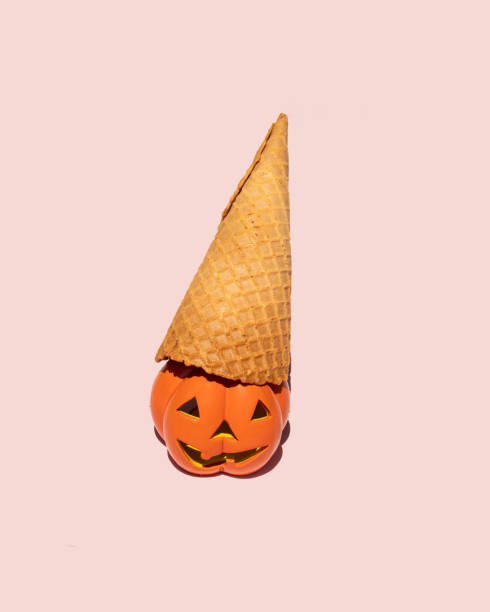 istock Creative Halloween concept. Scary pumpkin and ice cream cone on pastel pink background. Minimal holiday composition. 1418297882