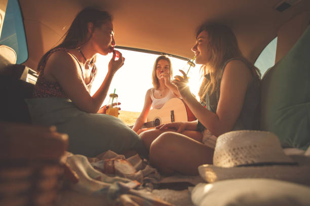 istock Girlfriends having fun at the back of a vehicle while making a road trip 1418307182