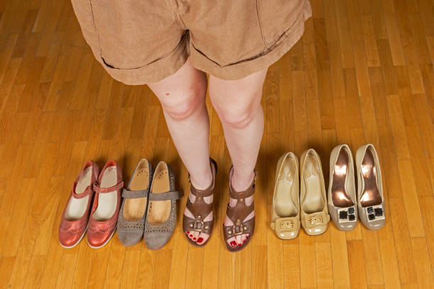 istock Woman standing surrounded by shoes 1418308346