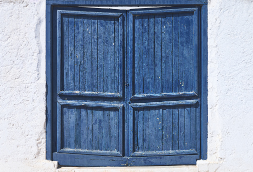 detail of an old blue wooden door on a white wall