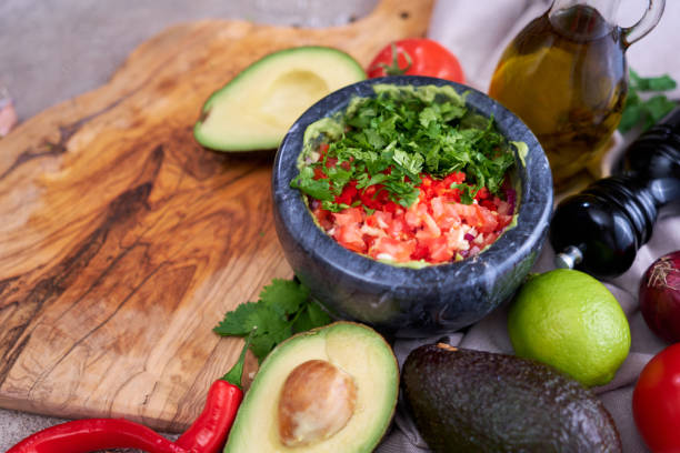 istock making guacamole - crushed avocado in marble mortar and ingredients 1418317505