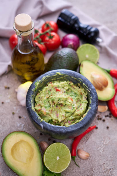 istock freshly made guacamole in marble mortar with ingredients on grey concrete background 1418317526