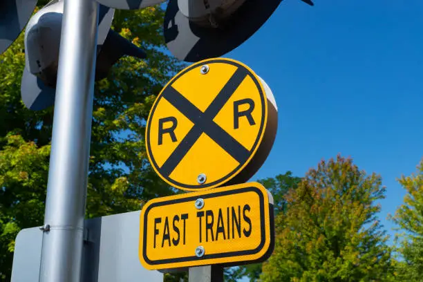 Railroad crossing sign with brilliant blue skies in the background.