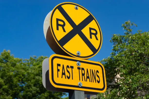 Railroad crossing sign with brilliant blue skies in the background.