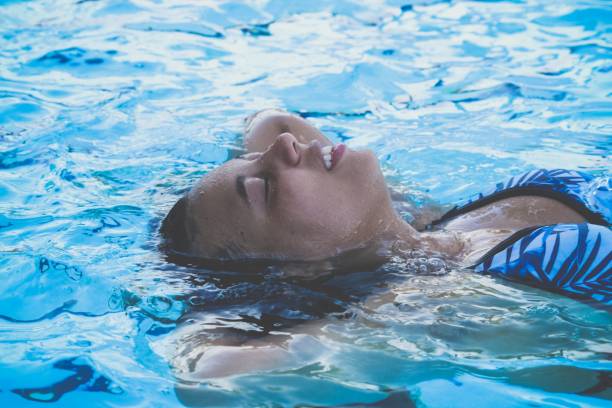 istock Young woman laying in water 1418332208