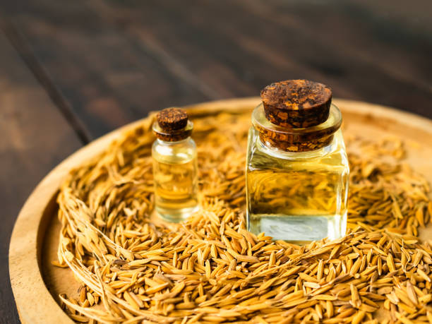 istock Rice Bran Oil in bottle Glass with seed rice background 1418332294