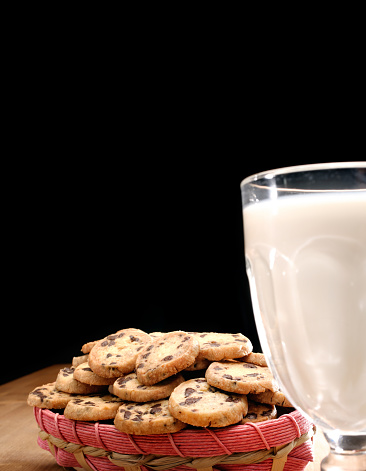 Homemade fresh chocolate chips cookies and glass of milk, Cookies and glass of milk on wooden table