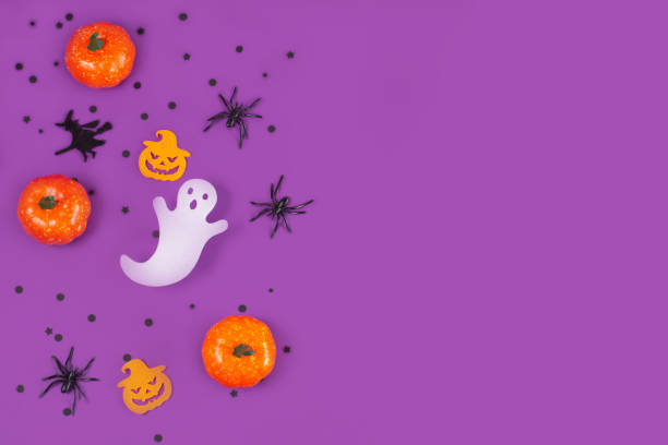 istock Halloween decorations pumpkins spiders with black confetti on violet background. 1418340560