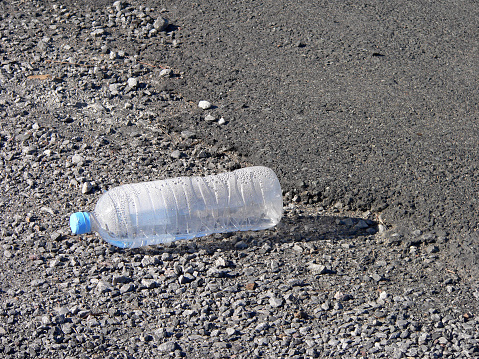 Discarded plastic water bottle by the side of the road
