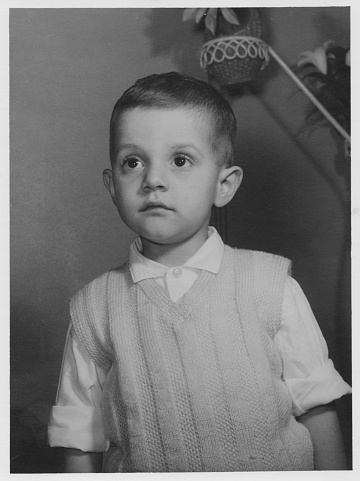 Black and white photo taken in the 60s:serious boy lookin away