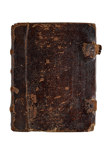 The book is bound in worn leather. Antiques. Vertical studio shot isolated on white.