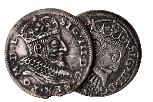 Two old silver coins 16th century isolated on white. Averse of triple groschen with portrait of Sigismund III Vasa, King of Poland and Grand Duke of Lithuania. Selective focus