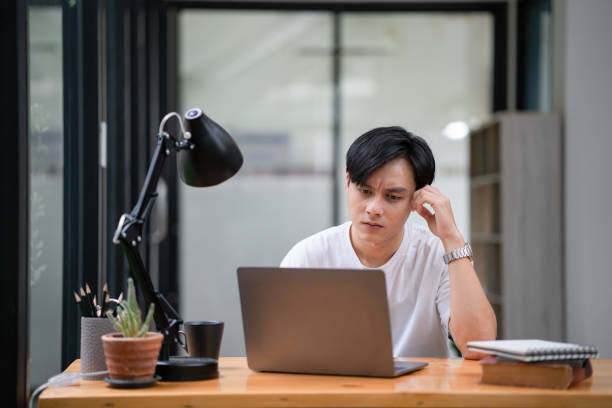 istock Sad depression serious people from work stress concept. Asian man feeling tired suffering using computer work workplace. 1418366460