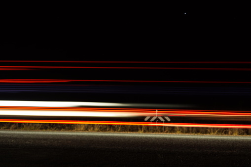 Slow shutter photo of lights from a car on a highway