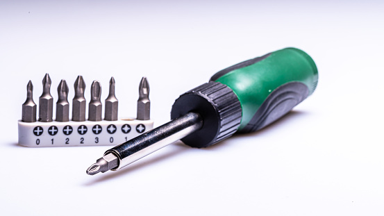 Interchangeable screwdriver set with different types of metal steel heads and bits, selective focus