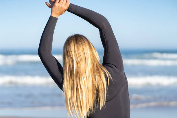 istock Surfer girl warming up at the beach 1418377463