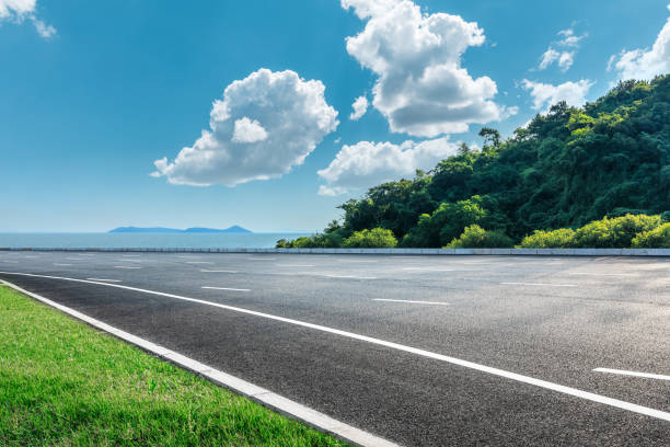 asphalt und wald am meer - straßenverkehr stock-fotos und bilder