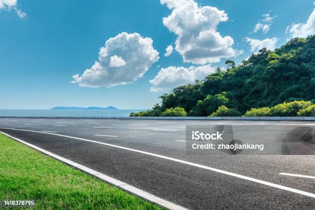 Asphalt And Forest By The Sea Stock Photo - Download Image Now - Road, Highway, Sky