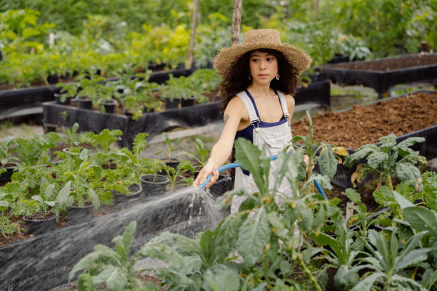 istock Attractive farmer enjoying while taking care of vegetable plot in garden. 1418380371