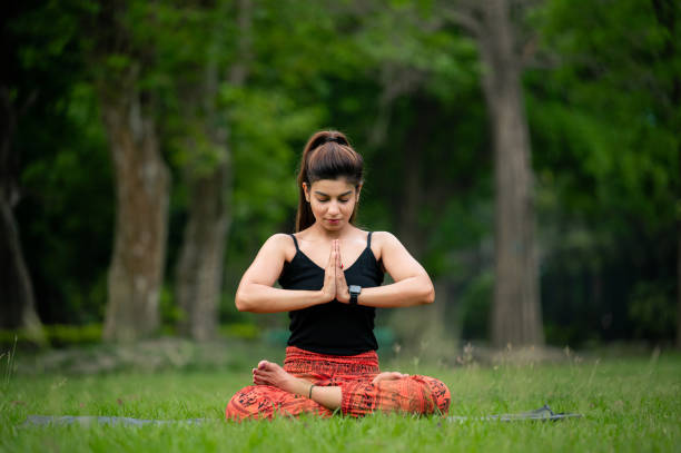 kobieta siedząca w pozycji lotosu sprawia, że namaste medytuje na świeżym powietrzu - zen like nature breathing exercise sitting zdjęcia i obrazy z banku zdjęć
