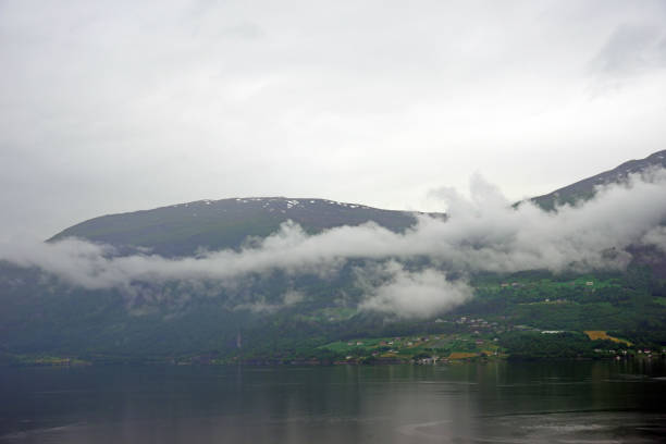 The Norwegian Fjord of Yri Neset, Norway, Europe. There is low cloud early in the morning looking down the Fjord.