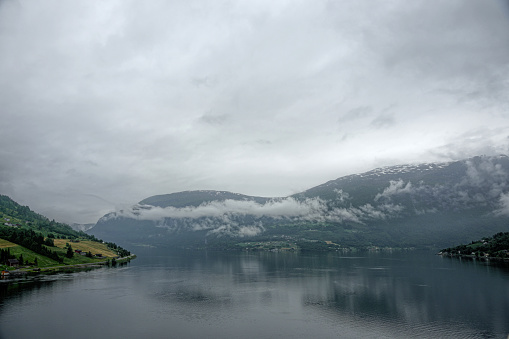 The Norwegian port of Olden, Norway, Europe. There is low cloud early in the morning looking down the Fjord.