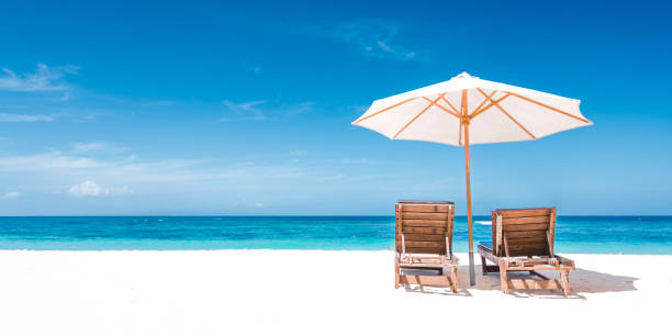 istock Couple Relaxing in Deck Chairs on Tropical Beach 1418393299