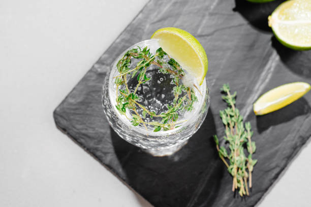 istock Alcoholic beverage with tonic and lime view from above. Background gray under concrete 1418396048