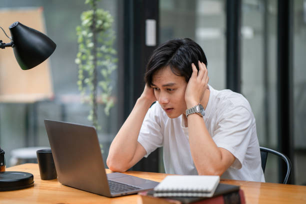 istock Sad depression serious people from work stress concept. Asian man feeling tired suffering using computer working work place. 1418397370
