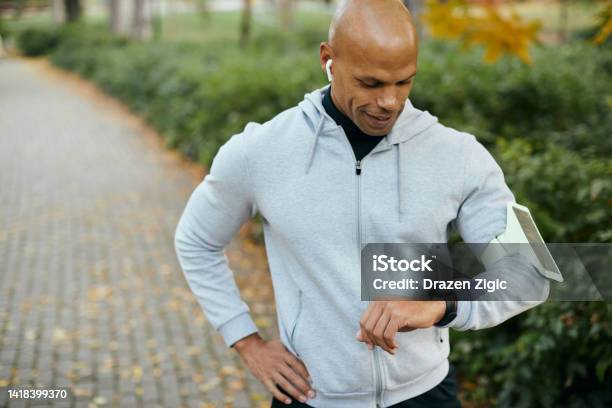 Young Black Athlete Using Fitness Tracker While Exercising In The Park Stock Photo - Download Image Now
