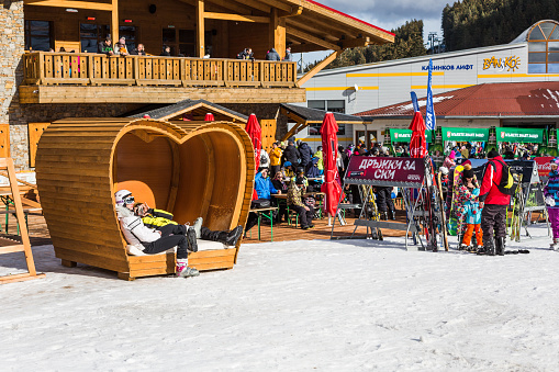 Bansko, Bulgaria - December 12, 2015: Bulgarian ski resort, heart shaped place bench, people walking and skiing