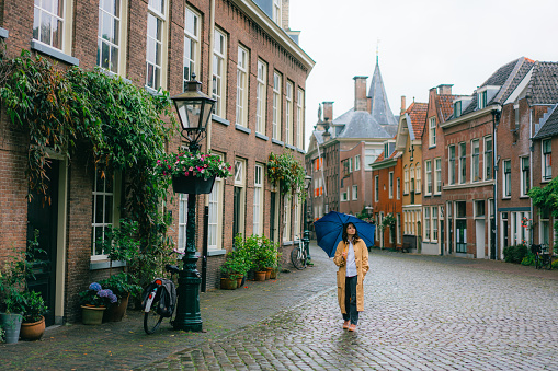Young Caucasian woman walking in Leiden under the rain