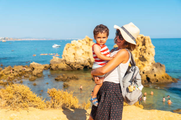 мать с сыном в прайя-дус-аррифеш, пляж алгарве, албуфейра. португалия. туризм летом - алгарве стоковые фото и изображения