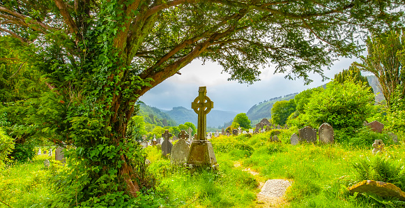 Ancient celtic cross in old Irish graveyard in Glendalough valley, Ireland travel photo