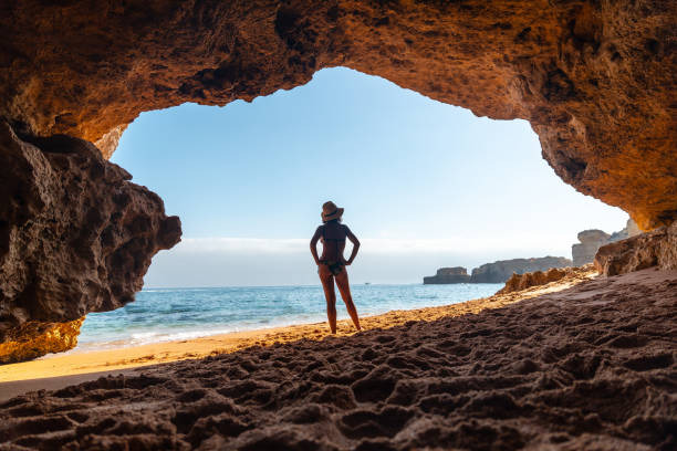 Silhouette of a woman in the cave on the beach in the Algarve, Praia da Coelha, Albufeira. Portugal stock photo