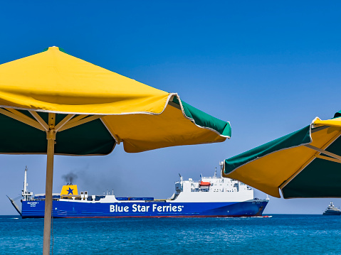 Kos Island, Greece - July 26, 2022: Side view on BLUE STAR FERRIES, a high speed catamaran traveling and connecting Aegean Islands with main land. Nautical summer travel background with copy space.
