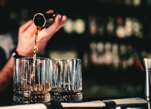 istock Bartender pouring whiskey on glass in bar 1418412069