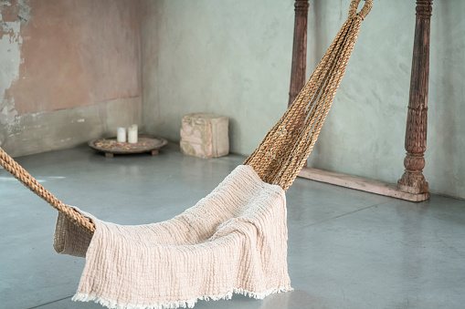 Comfortable hammock in stylish light boho room. Interior design. Romantic, cozy vibes. Real photo.