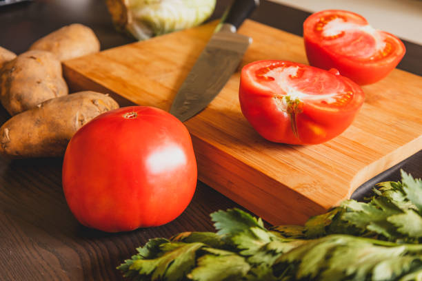 cut tomato on wooden board at the kitchen table