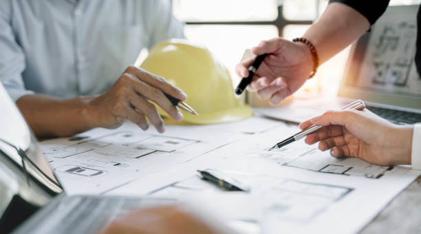 istock engineer meeting for architectural project. working with partner and blueprint on workplace. 1418413785
