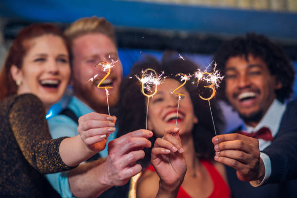 dos parejas con luces de bengala - happy new year fotografías e imágenes de stock
