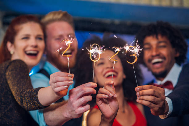 Two couples with sparklers Young happy people looking at sparklers in their hands new year party stock pictures, royalty-free photos & images