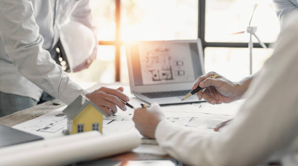 istock engineer meeting for architectural project. working with partner and blueprint on workplace vintage tone. 1418414543