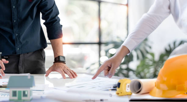 istock Hands of creative team discussing plan of the building. Architects or engineering discussing project together at the meeting in the office. 1418414702
