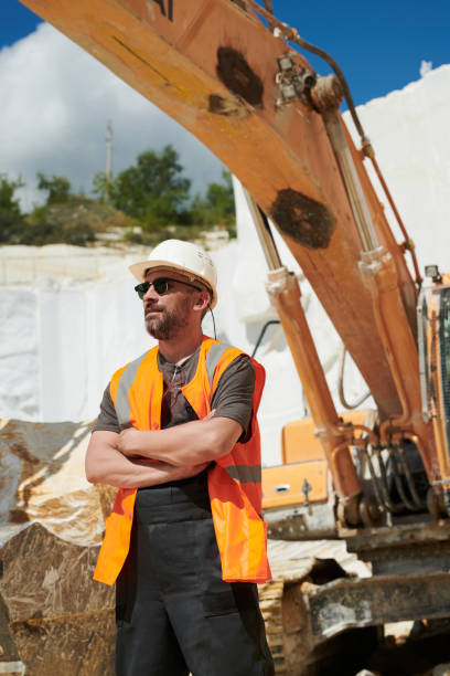 istock Confident mature foreman in eyeglasses, reflection vest, uniform and hardhat 1418436678