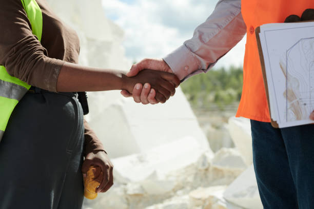 istock Close-up of two intercultural workers of marble quarry shaking hands 1418436736